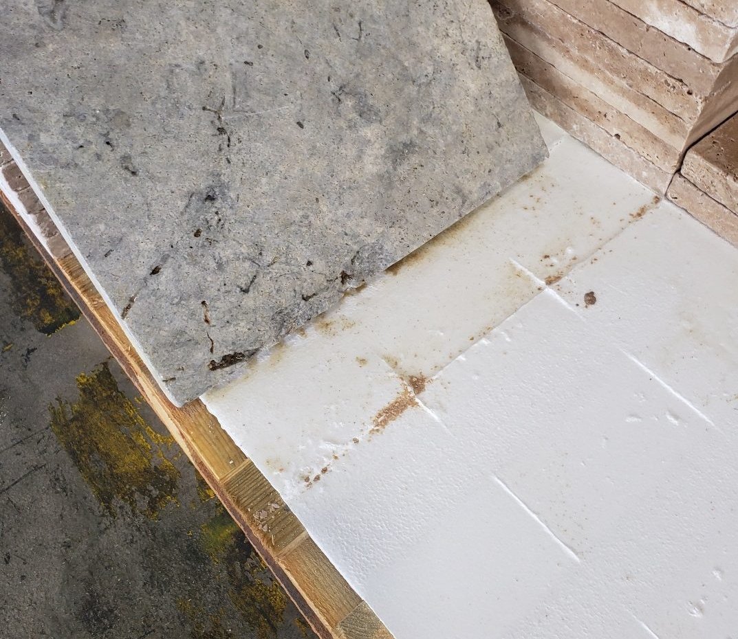 Same paver after bleach treatment with stone lifted — iron transferred to white surface below