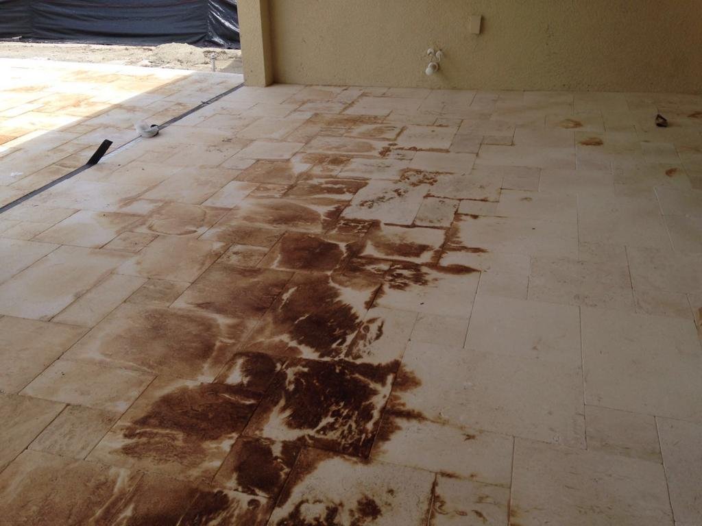 Severe iron staining migrating across Myra limestone pavers from sand bed below